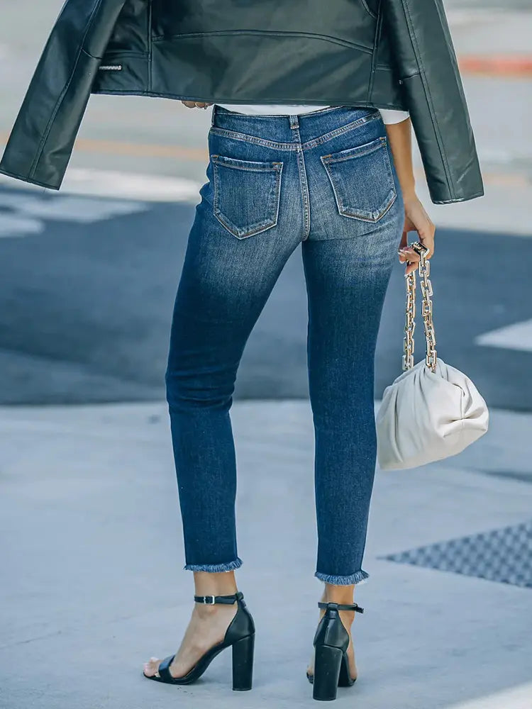 Jeans elásticos abotonados, rotos y de largo hasta el tobillo.